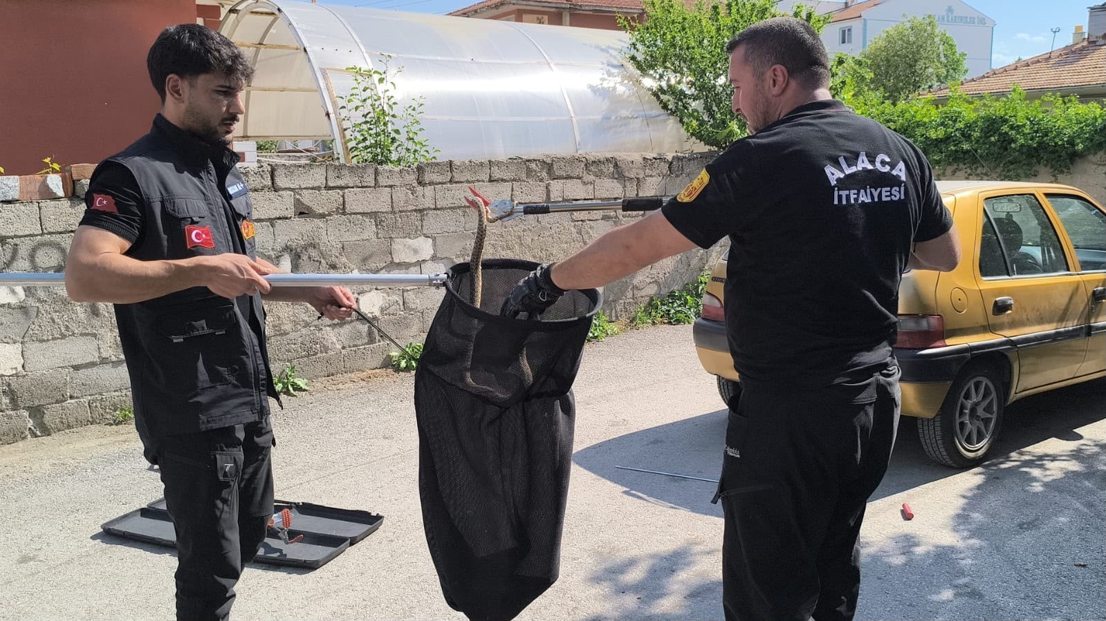 Otomobilin altına giren yılan itfaiye ekiplerince çıkarıldı