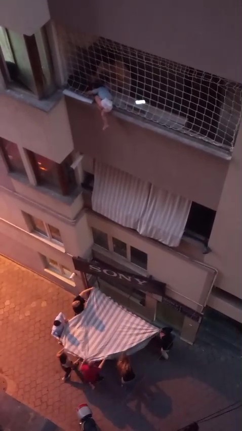 Balkon filesinde asılı kalan çocuğunu düşmesin diye dakikalarca tuttu