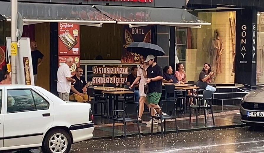 Antalya’da aniden bastıran yağmur, tatilcilere temmuz ayında şemsiye açtırdı