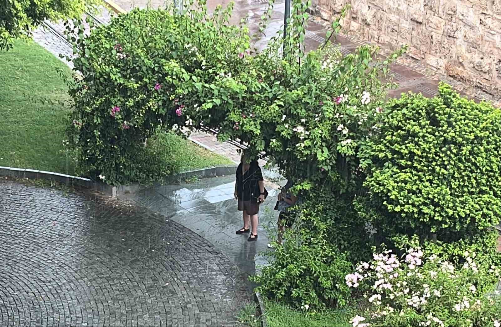 Antalya’da aniden bastıran yağmur, tatilcilere temmuz ayında şemsiye açtırdı