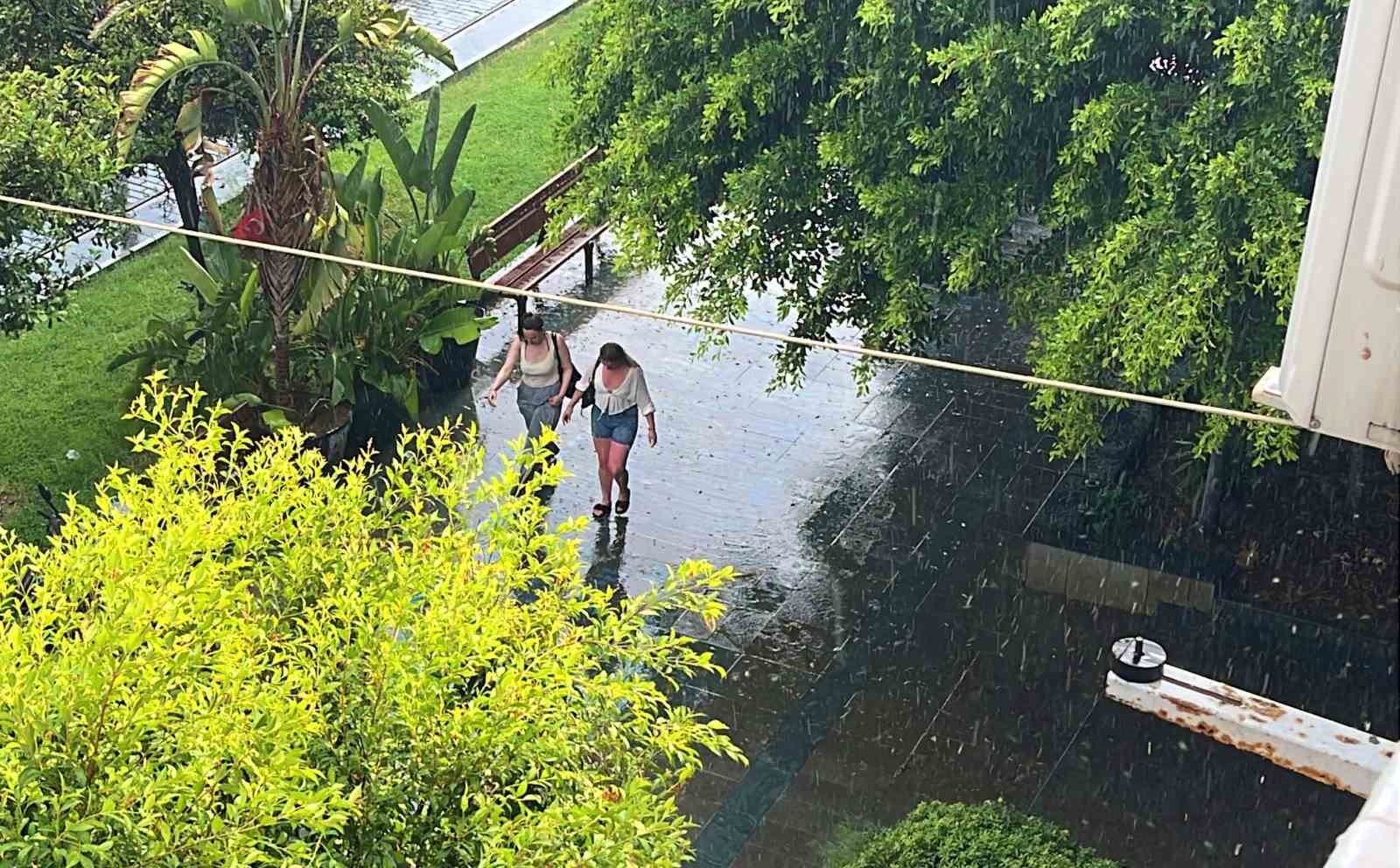 Antalya’da aniden bastıran yağmur, tatilcilere temmuz ayında şemsiye açtırdı