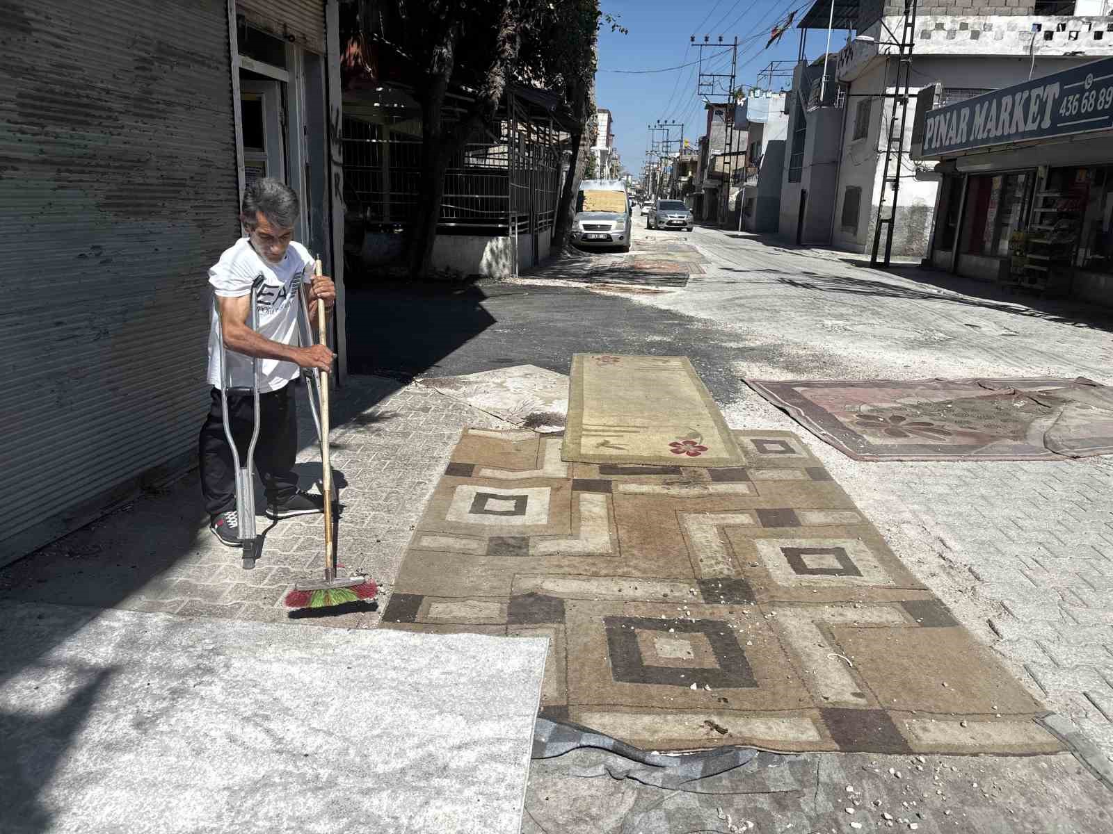 Tozdan bunalan mahalleli çareyi sokağa halı sermekte buldu
