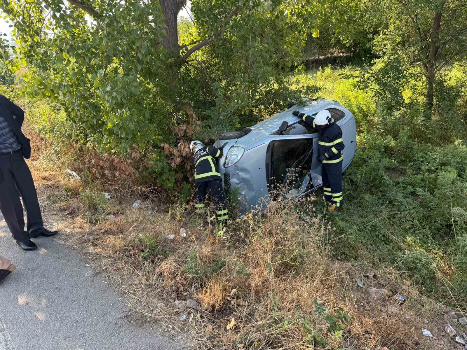 Yoldan çıkan otomobil ağaçlık alanda yan yattı