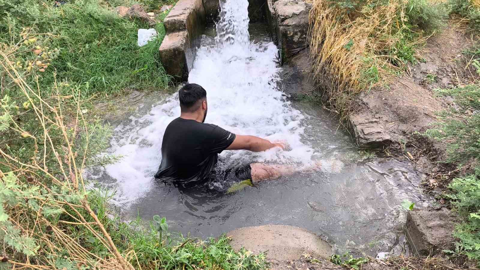 Kavurucu sıcakta elbisesini bile çıkarmadan buz gibi sondaj suyunda serinledi