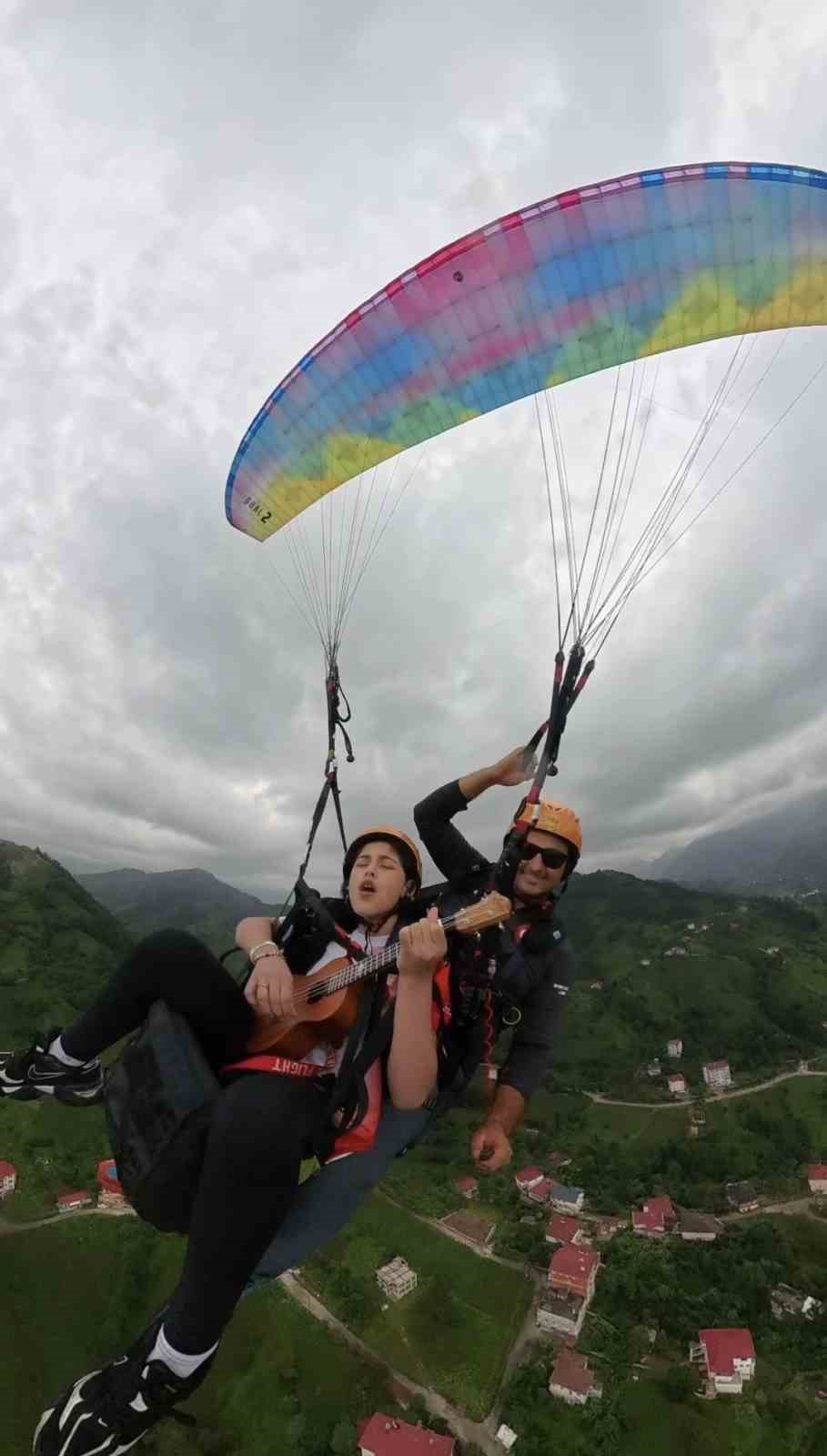 13 yaşındaki Asya yamaç paraşütü ile gökyüzünde ukulele çalıp şarkı söyledi