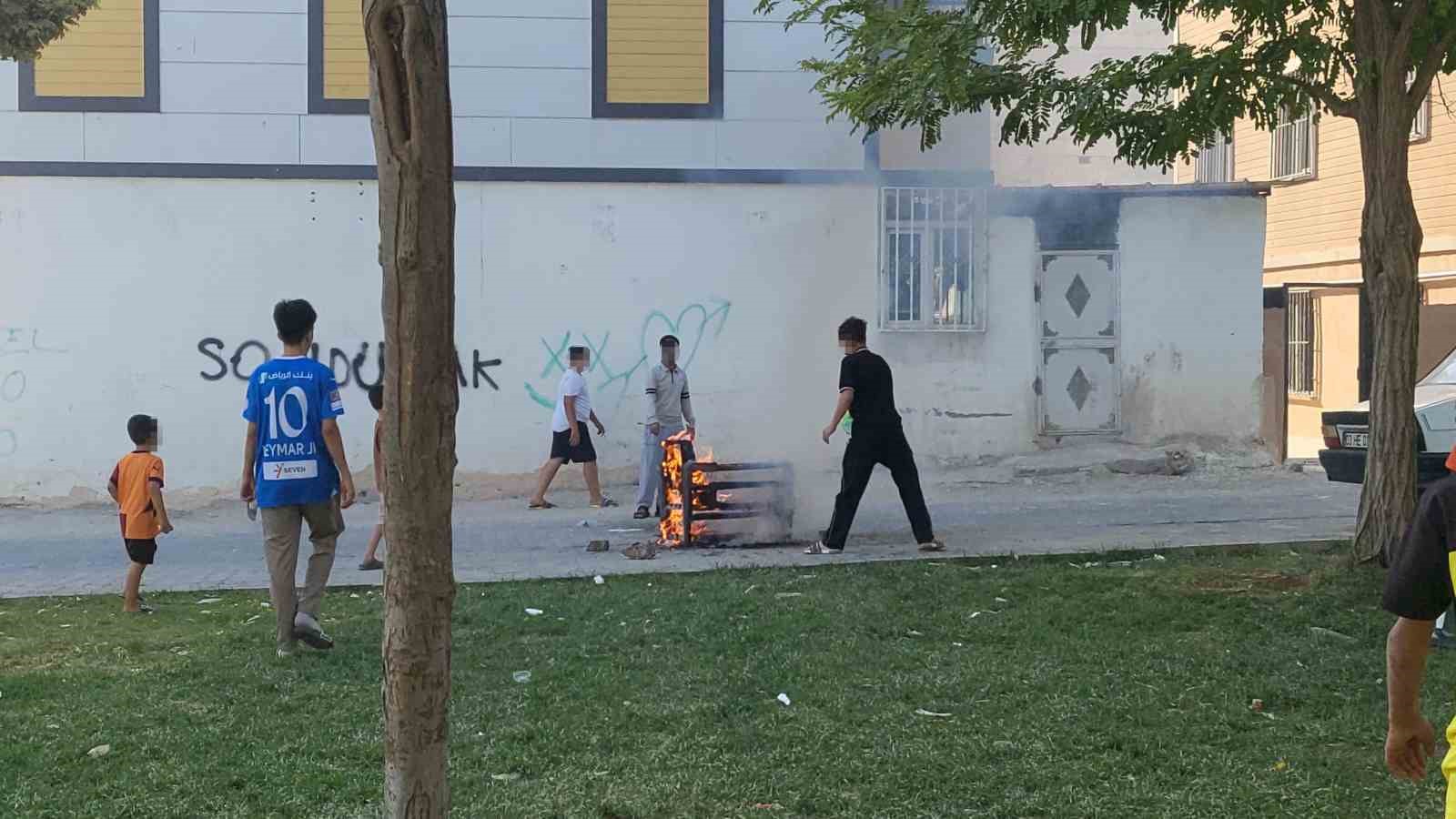 Sokaktaki koltuğu ateşe veren çocuklar sonra söndürmeye çalıştı