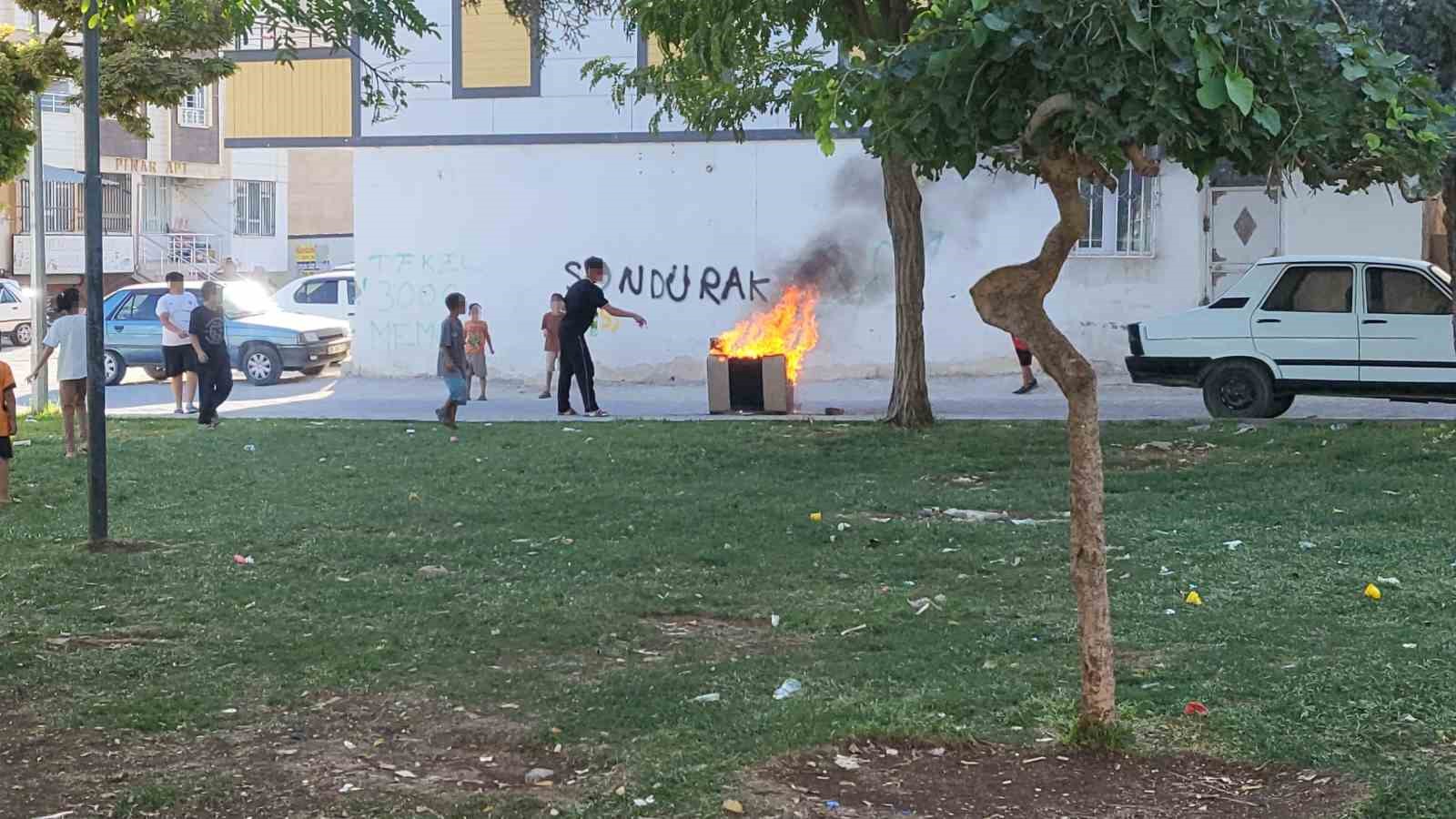 Sokaktaki koltuğu ateşe veren çocuklar sonra söndürmeye çalıştı