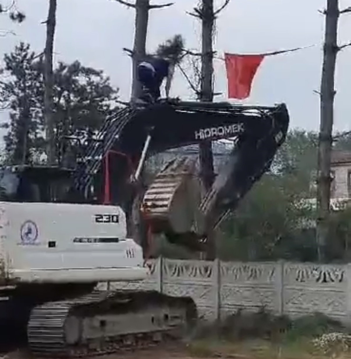 İş makinesinin üzerine çıkıp Türk bayrağını düzeltti, ardından böyle öptü