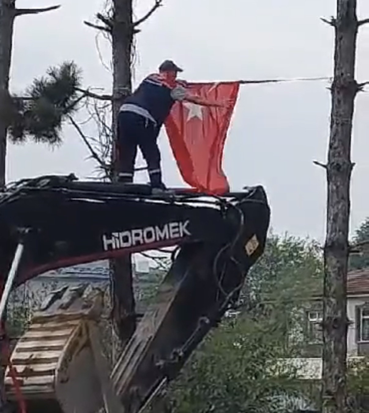 İş makinesinin üzerine çıkıp Türk bayrağını düzeltti, ardından böyle öptü
