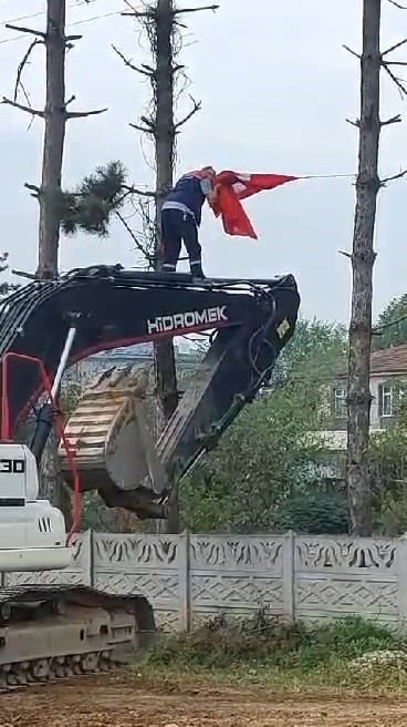 İş makinesinin üzerine çıkıp Türk bayrağını düzeltti, ardından böyle öptü
