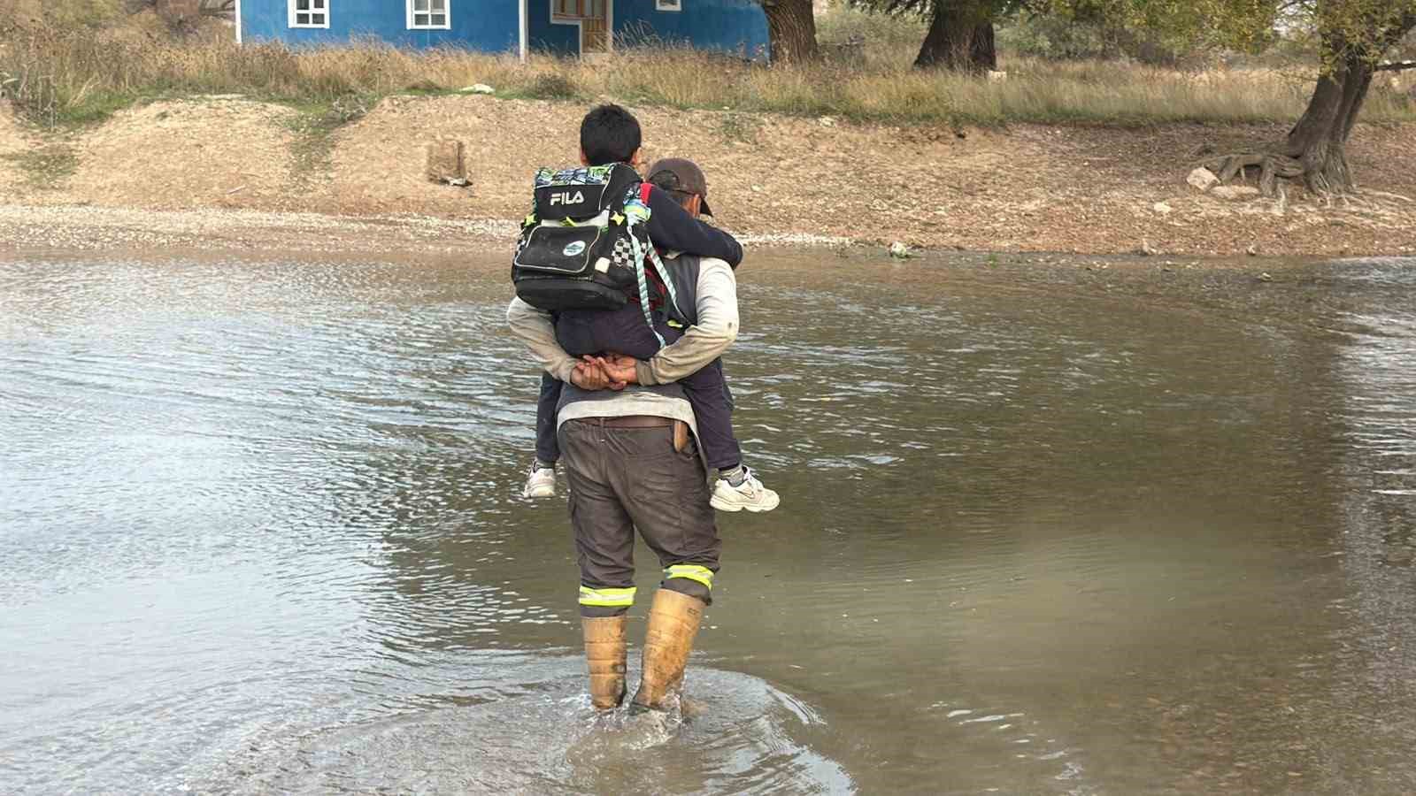 Köprü yıkılınca evladını her gün sırtında taşıyıp ırmaktan geçiriyor